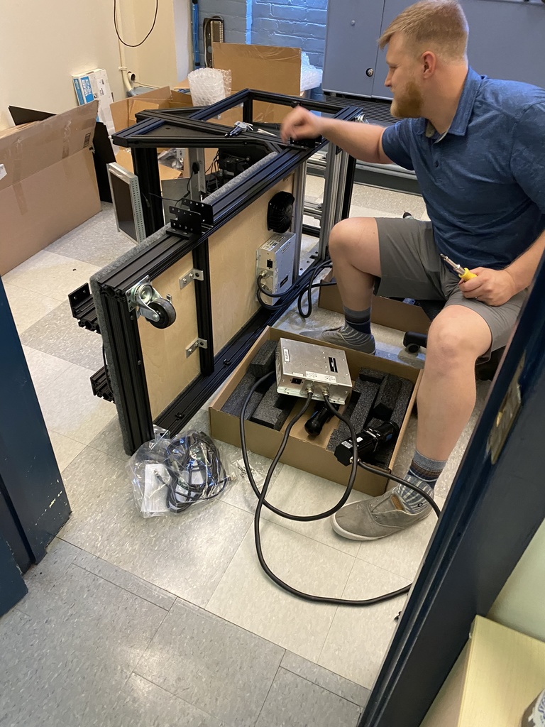 Recent University of Iowa engineering graduate Aidan Keen installs the motion base system at the University of Toronto