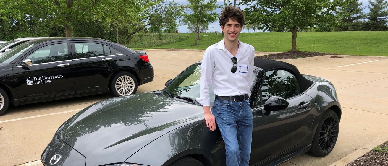 Thomas outside of NADS leaning against his Mazda Miata